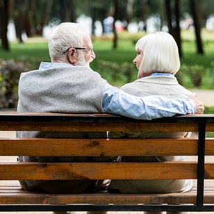 Older couple sitting on a park bench.