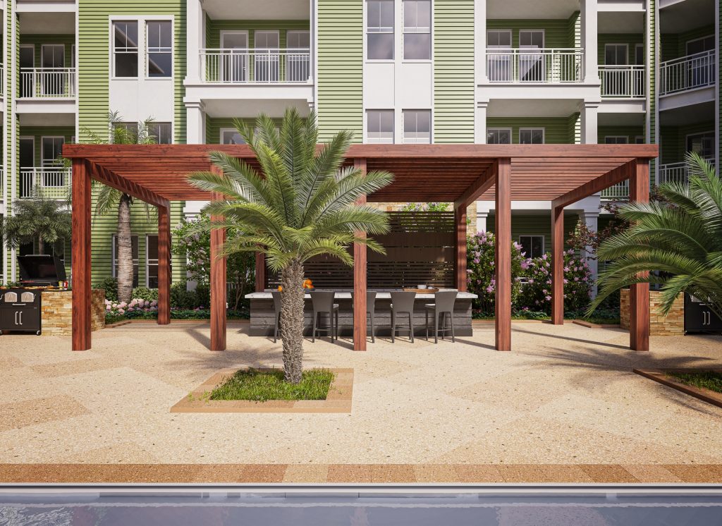Outdoor patio area with bar seating, landscaping and community grills