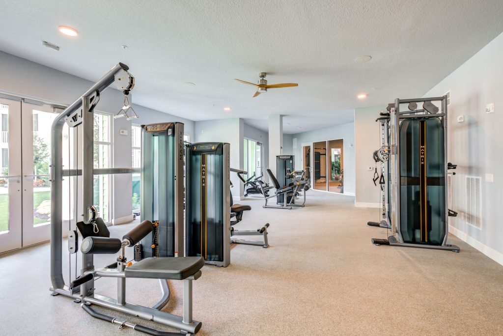 Indoor gym with lifting machines, workout machines, and weights