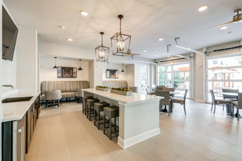 Indoor clubhouse dining area with island and lounge seating, single sink, and wood-style flooring