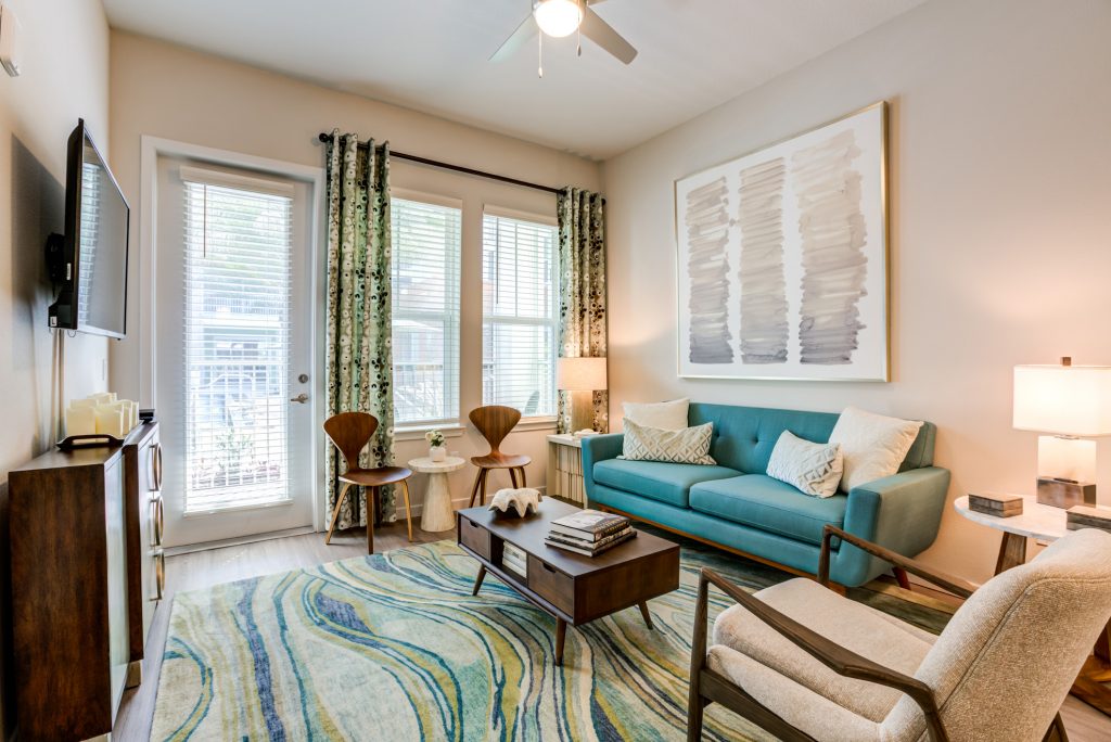 Living room area with couch, tv, lounge seating, wood-style flooring and outdoor patio access