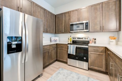 Kitchen area with steel appliances, wood cabinets, and wood-style flooring