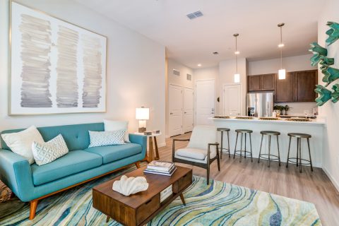 Living room area with couch, wood and ocean decor, wood-style flooring and island seating